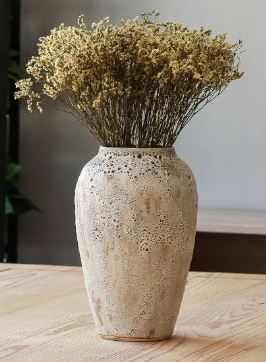 Ceramic vase with dried pampas grass stems on shelf